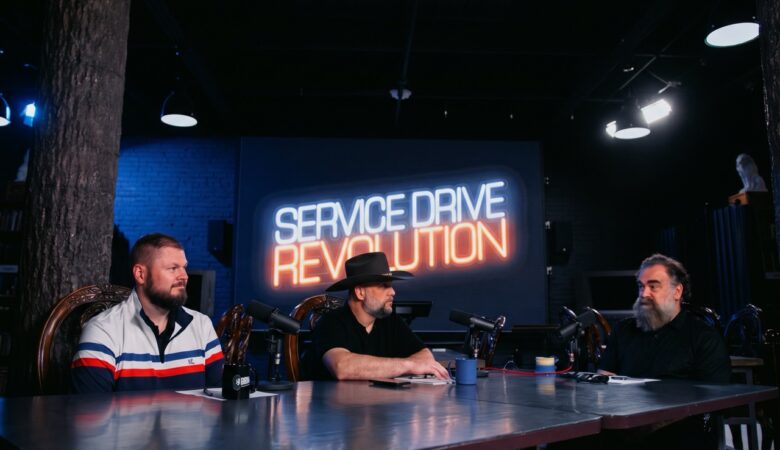 Service manager holding a focused one-on-one coaching meeting with a service advisor